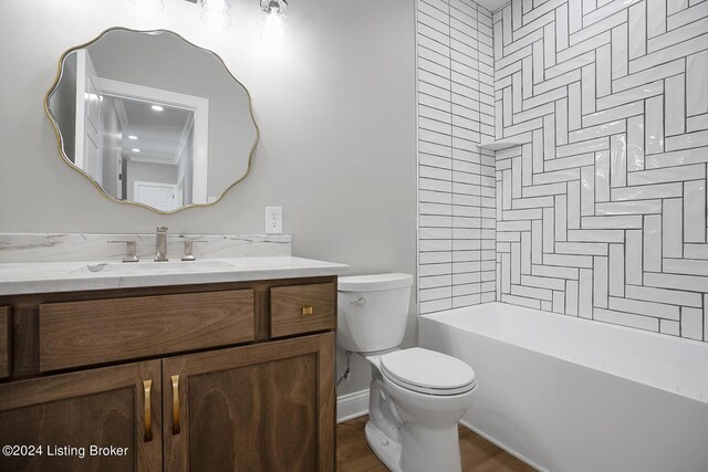 full bathroom featuring tiled shower / bath, vanity, and toilet