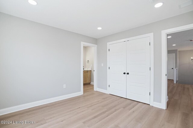 unfurnished bedroom with a closet and light hardwood / wood-style floors