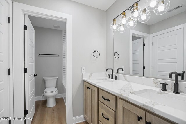 bathroom featuring a tub to relax in, vanity, toilet, and hardwood / wood-style flooring