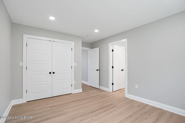 unfurnished bedroom featuring light wood-type flooring and a closet