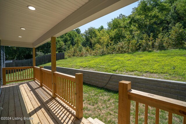 wooden deck featuring a lawn