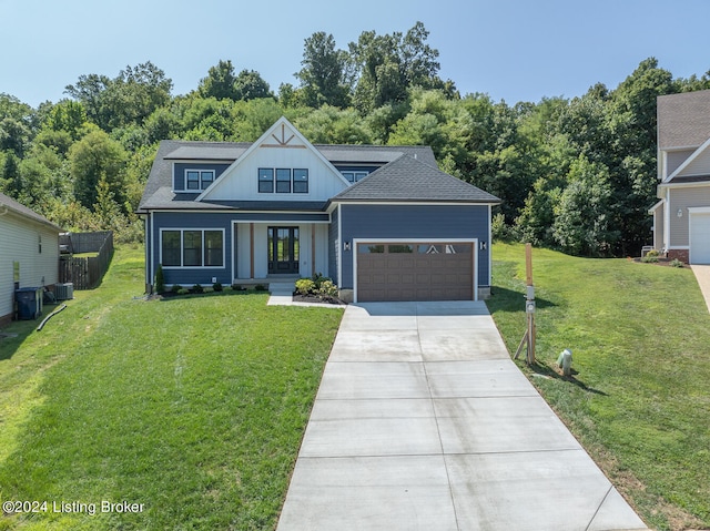 view of front of house featuring central air condition unit, a front yard, and a garage