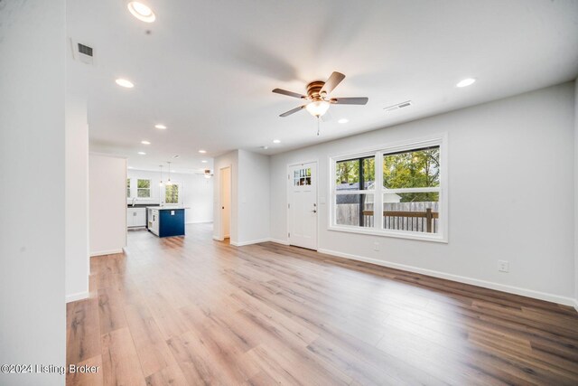 unfurnished living room with light hardwood / wood-style flooring, plenty of natural light, and ceiling fan