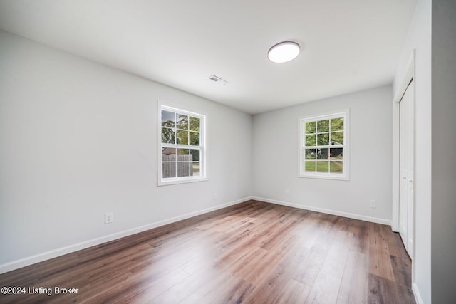 spare room with hardwood / wood-style flooring and a wealth of natural light