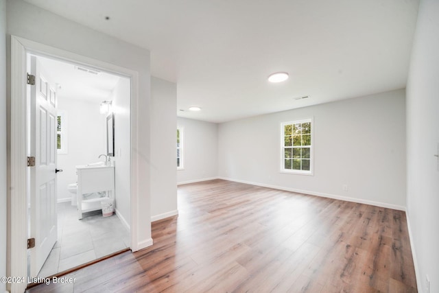 empty room with light wood-type flooring and sink