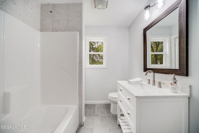 full bathroom featuring washtub / shower combination, plenty of natural light, vanity, and toilet