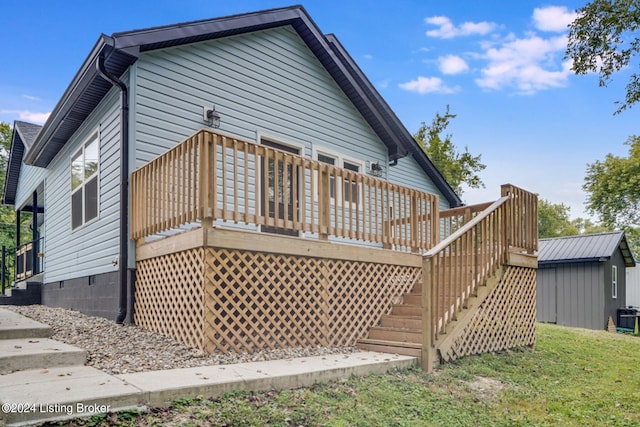 back of property featuring a shed and a deck