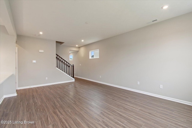 empty room with stairs, baseboards, recessed lighting, and wood finished floors