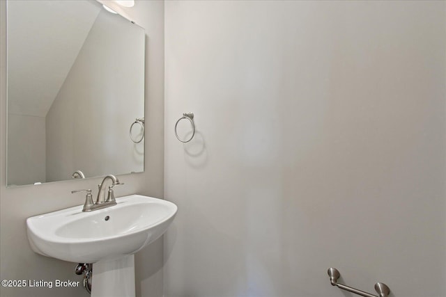 bathroom with a sink and lofted ceiling