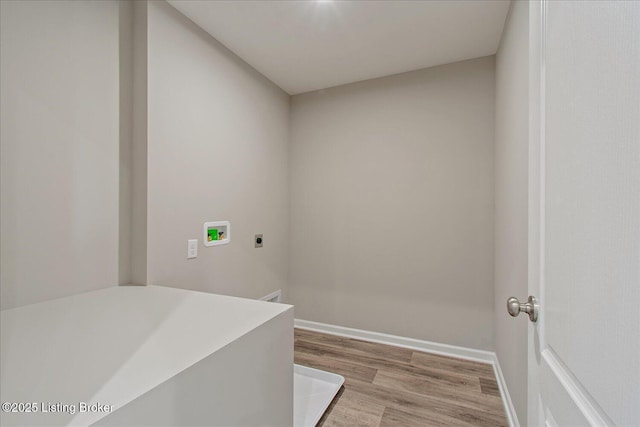 laundry room featuring electric dryer hookup, hookup for a washing machine, wood finished floors, and baseboards