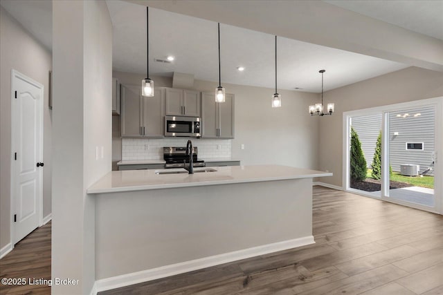 162 Harvest Point Way, Mt Washington, KY 40047 - kitchen featuring appliances with stainless steel finishes, gray cabinets, dark wood-style flooring, decorative backsplash, and light countertops
