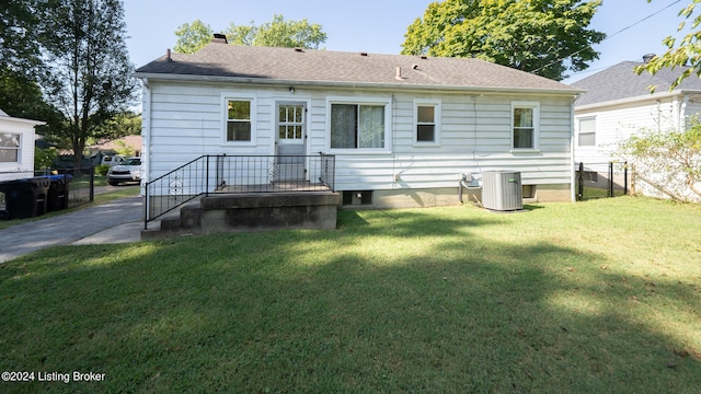 back of property with a lawn and central AC unit