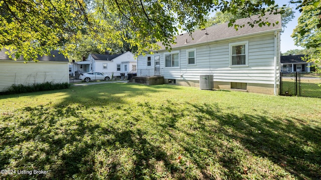 back of house with a lawn and central AC