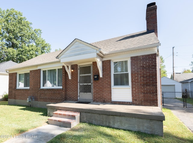 view of front of house featuring an outdoor structure, a garage, and a front lawn