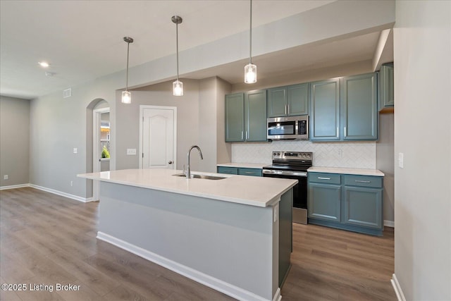 196 Harvest Moon Ct Unit 219A, Shepherdsville, KY 40165 - kitchen featuring a sink, stainless steel appliances, arched walkways, decorative backsplash, and dark wood-style flooring