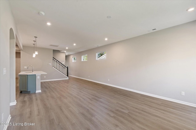196 Harvest Moon Ct Unit 219A, Shepherdsville, KY 40165 - unfurnished living room with a sink, light wood-style flooring, arched walkways, baseboards, and recessed lighting