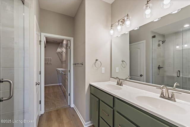 196 Harvest Moon Ct Unit 219A, Shepherdsville, KY 40165 - bathroom with a shower stall, double vanity, wood finished floors, a spacious closet, and baseboards