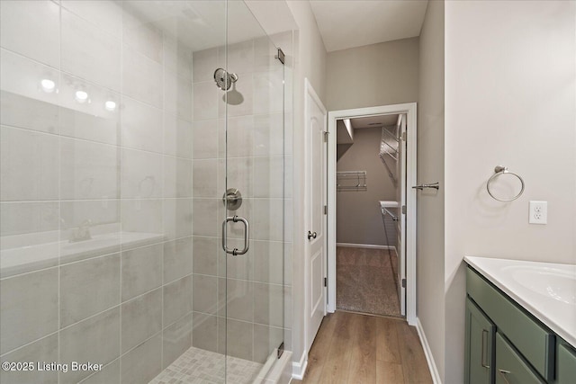 196 Harvest Moon Ct Unit 219A, Shepherdsville, KY 40165 - full bath featuring wood finished floors, a stall shower, a walk in closet, vanity, and baseboards