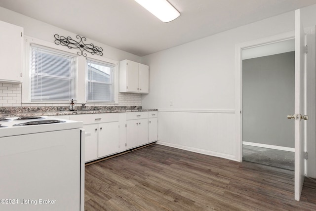 kitchen featuring stove, backsplash, white cabinets, and dark hardwood / wood-style floors