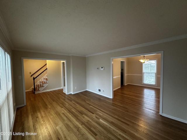 empty room with ornamental molding, stairway, baseboards, and wood finished floors