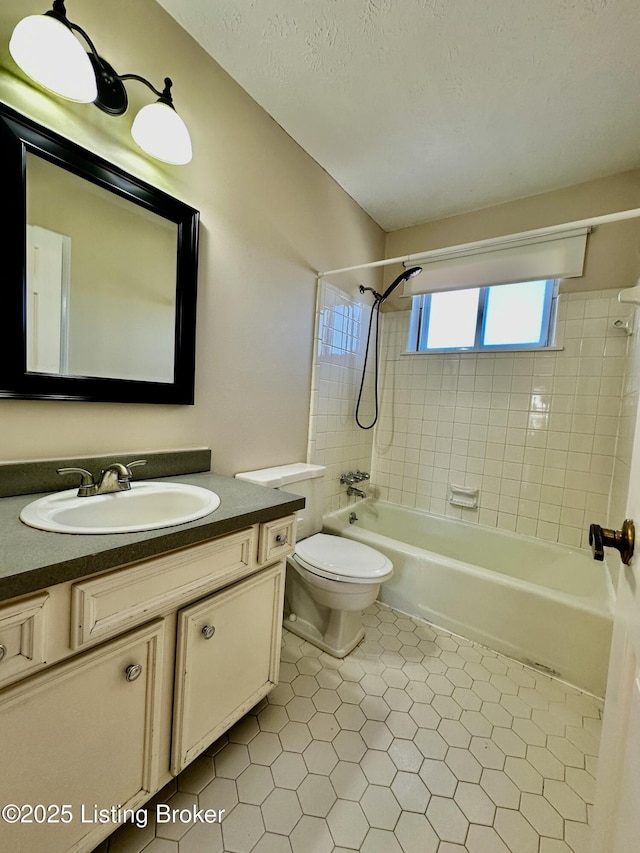 bathroom featuring bathing tub / shower combination, toilet, tile patterned flooring, a textured ceiling, and vanity