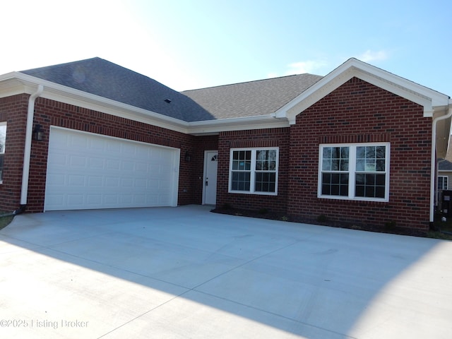 ranch-style house with brick siding, concrete driveway, a garage, and roof with shingles