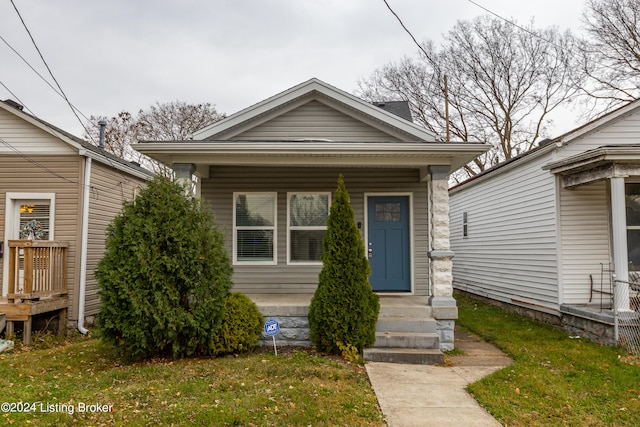 bungalow-style home with a front yard