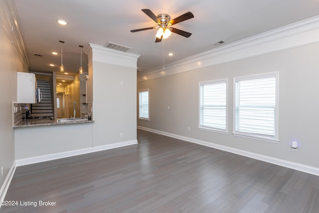 unfurnished living room featuring ornamental molding, ceiling fan, and dark hardwood / wood-style floors