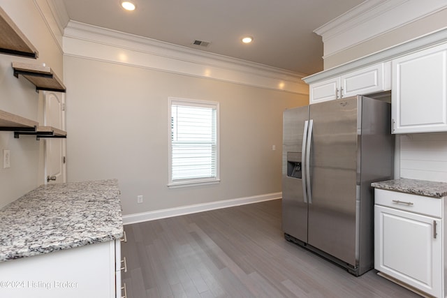 kitchen featuring stainless steel fridge, hardwood / wood-style flooring, white cabinetry, and ornamental molding