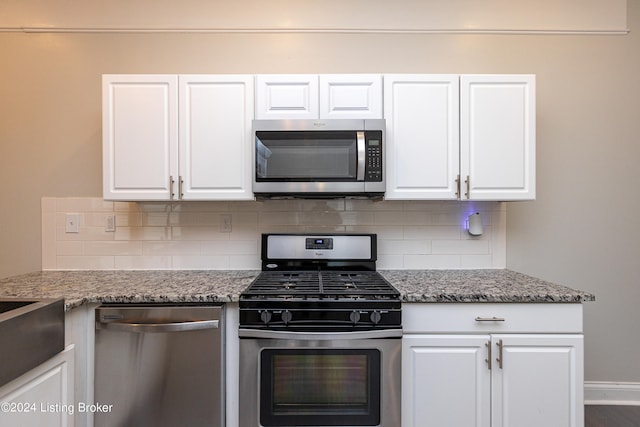 kitchen featuring backsplash, light stone counters, stainless steel appliances, and white cabinetry