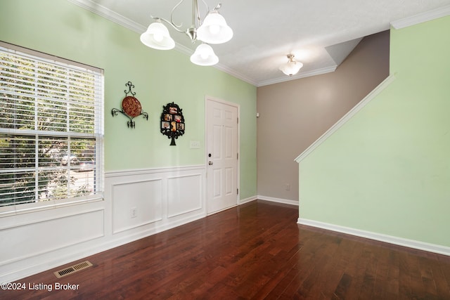 entryway featuring crown molding, a healthy amount of sunlight, dark hardwood / wood-style floors, and a notable chandelier