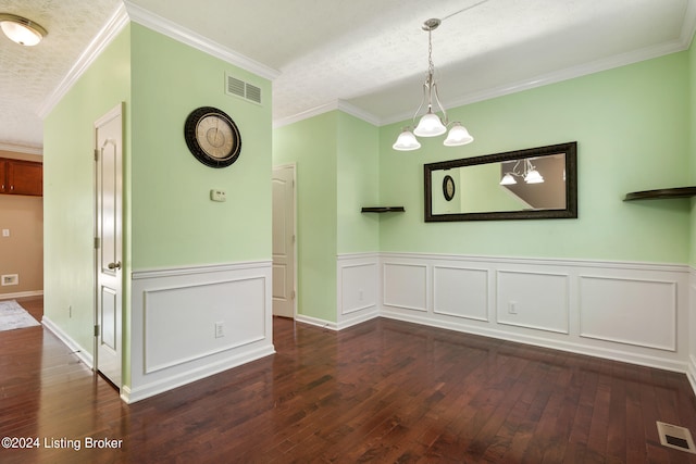 unfurnished dining area with a textured ceiling, a notable chandelier, crown molding, and dark wood-type flooring