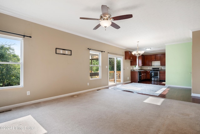 unfurnished living room featuring dark colored carpet, ceiling fan with notable chandelier, crown molding, and sink