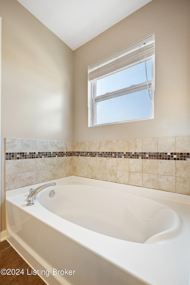 bathroom with tile patterned floors and a washtub