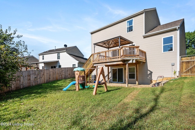 back of house featuring a yard, a playground, and a wooden deck