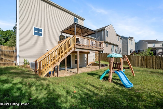 rear view of property featuring a yard, a playground, central AC unit, and a wooden deck