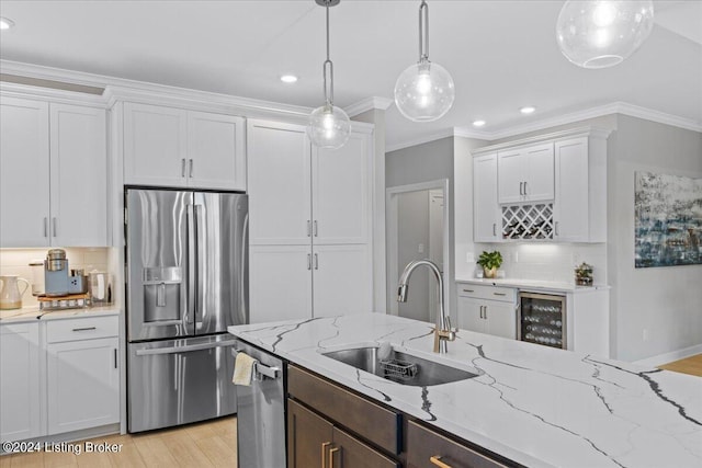 kitchen with light hardwood / wood-style floors, sink, white cabinets, backsplash, and appliances with stainless steel finishes