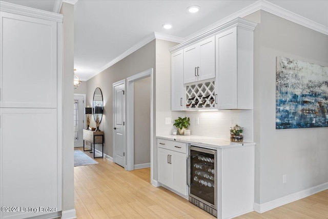 bar with light wood-type flooring, wine cooler, and white cabinets