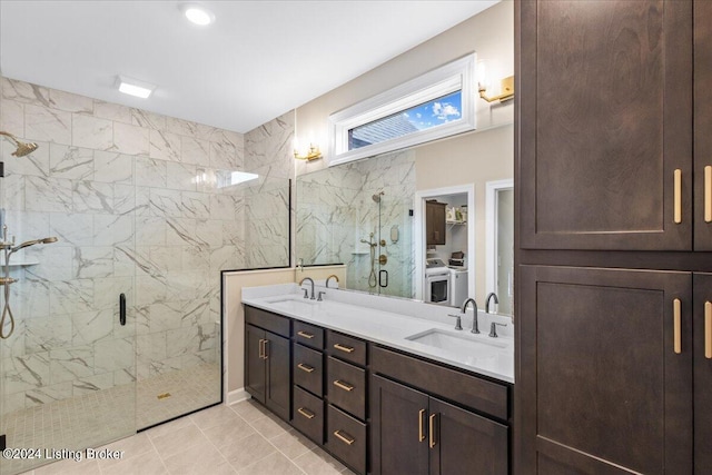 bathroom featuring walk in shower, vanity, washing machine and dryer, and tile patterned floors