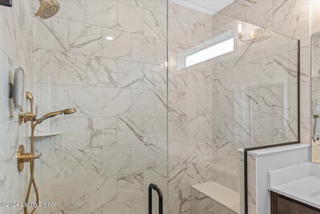 bathroom with tiled shower and vanity