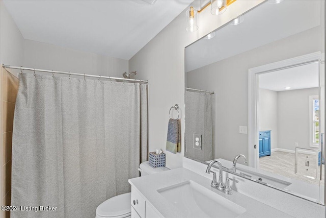 bathroom with walk in shower, vanity, and toilet