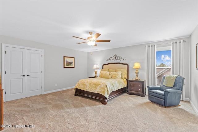 carpeted bedroom with ceiling fan and a closet