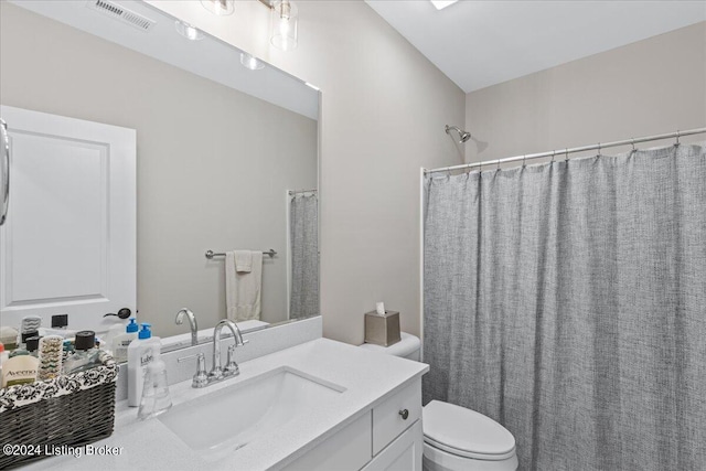 bathroom with a shower with shower curtain, vanity, and toilet