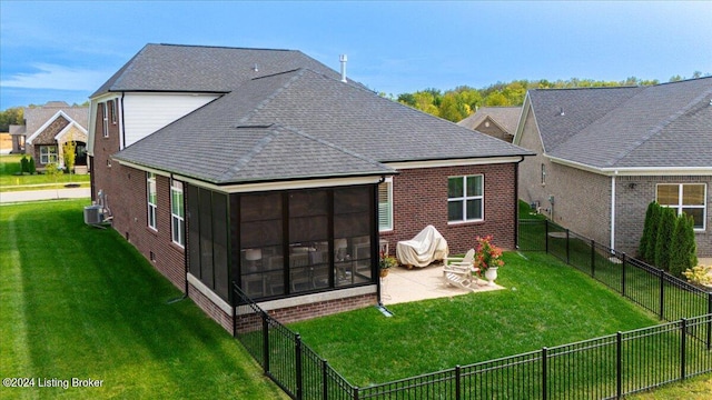 rear view of house featuring a sunroom, a yard, and a patio area