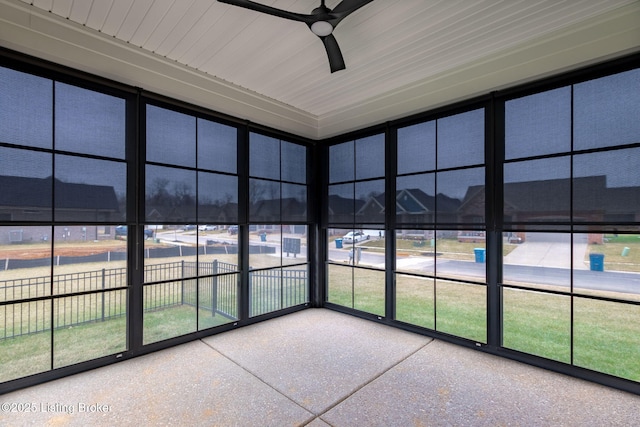 unfurnished sunroom with ceiling fan