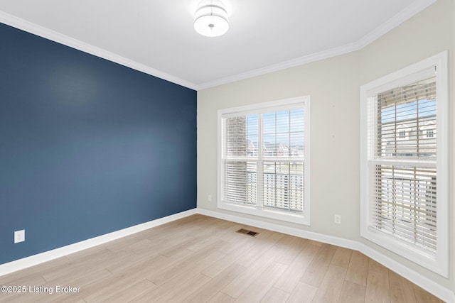 unfurnished room with ornamental molding and light wood-type flooring