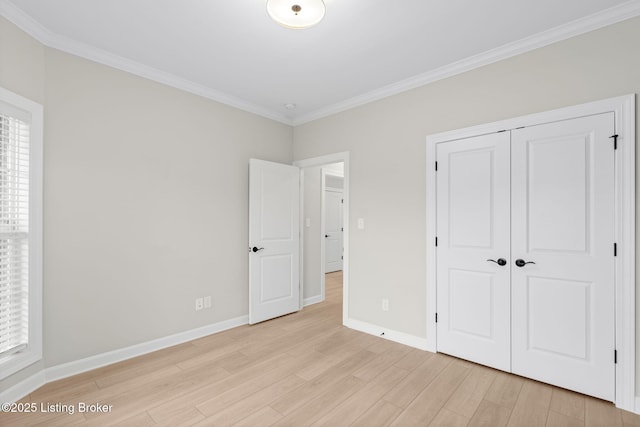 unfurnished bedroom featuring light hardwood / wood-style flooring, ornamental molding, and a closet