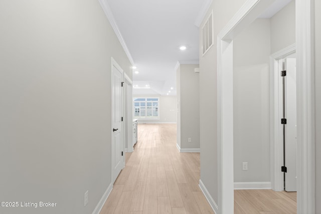 corridor with light hardwood / wood-style flooring and ornamental molding