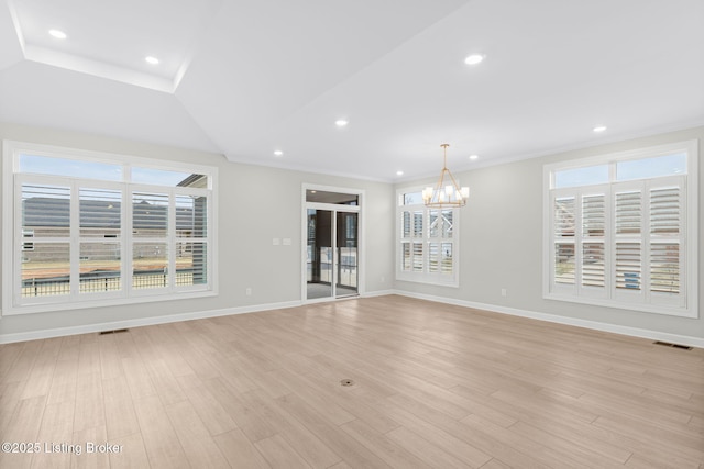 unfurnished living room with ornamental molding, a wealth of natural light, light hardwood / wood-style floors, and a notable chandelier