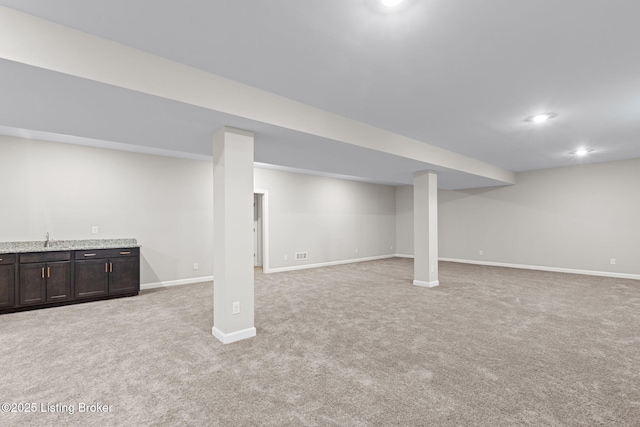 basement featuring light carpet and wet bar